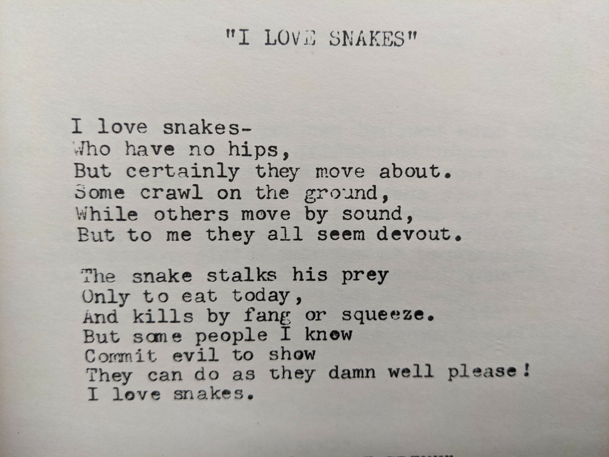 Typewritten poem in black on white background "I LOVE SNAKES"