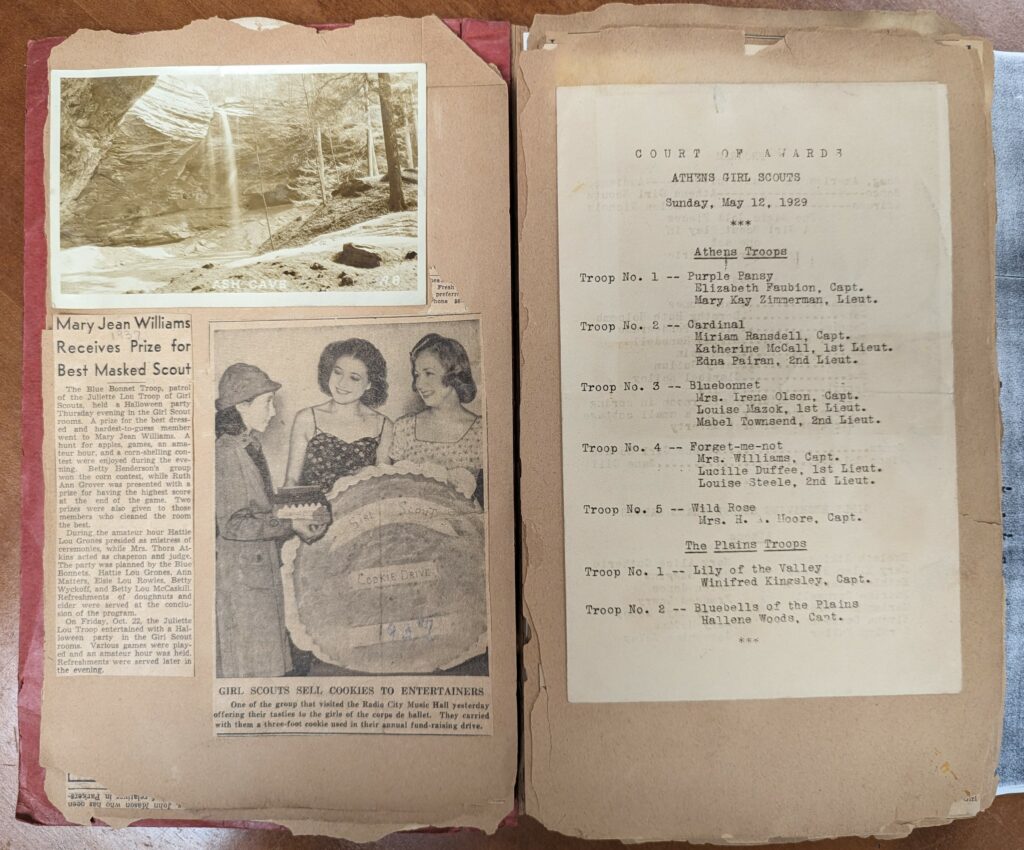 Athens Girl Scout scrapbook open to pages with an Ash Cave postcard, two newspaper clippings about awards and selling cookies, and a program from the "Court of Awards" ceremony held on May 12, 1929.