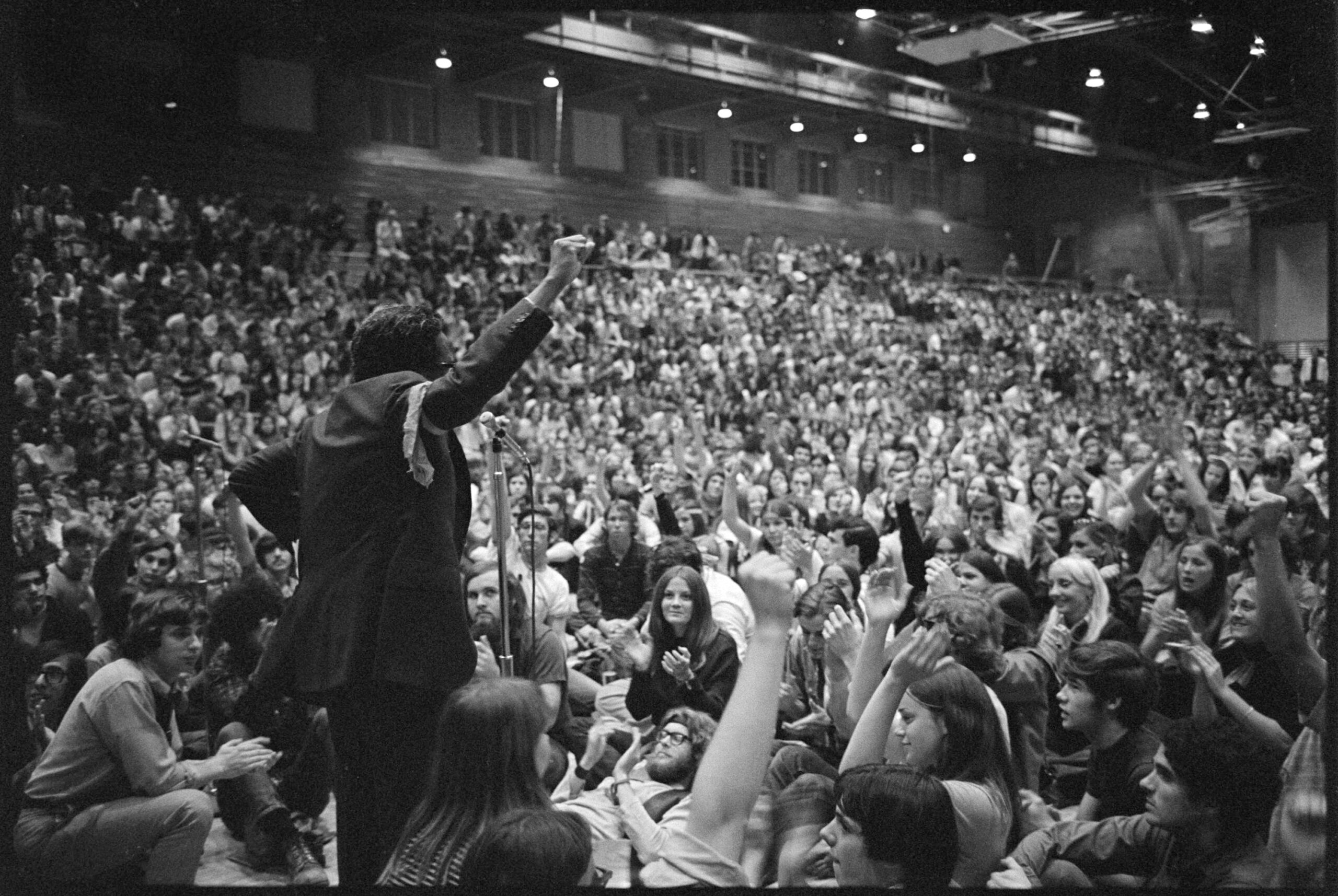 Photographer Gordon Parks raises his fist while speaking at a student rally