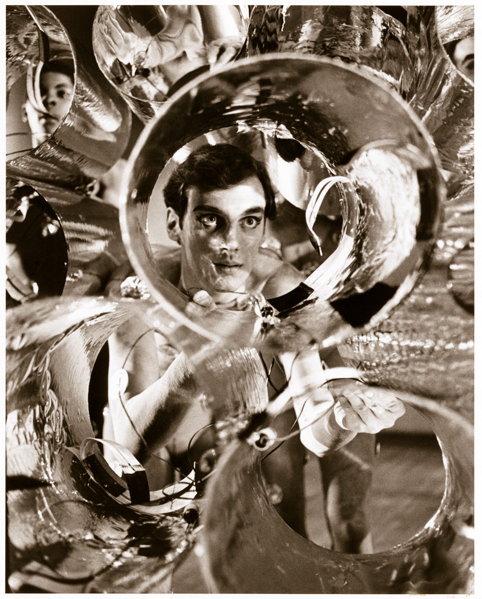 A dancer looks through a reflective circular tube during a performance of "Vaudeville of Elements", created by Alwin Nikolais