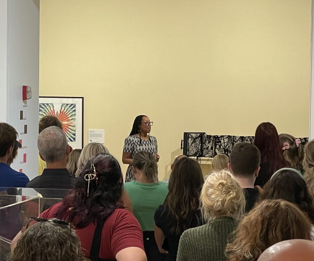 Sauda Mitchell speaking next to her book, Finding Aid, during the Gallery Walk & Talk, Kennedy Museum of Art