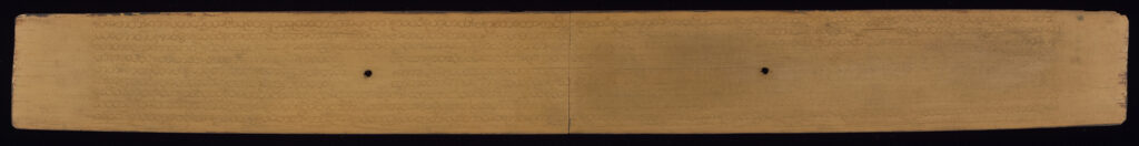 Front side of palm leaf manuscript with very faint text inscribed and two holes