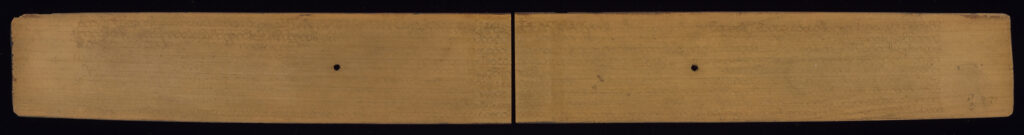 Back side of palm leaf manuscript with very faint text inscribed and two holes