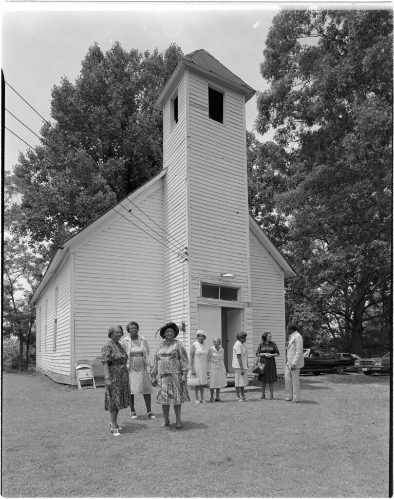 Black congregation members talking in small groups outside historical Macedonia Missionary Baptist Church in Burlington, Ohio, July 8, 1979