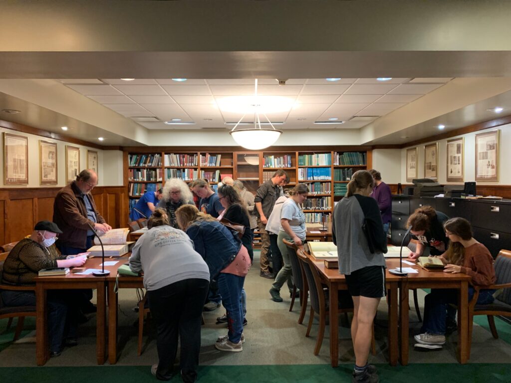 A group of community researchers exploring medieval manuscripts and facsimiles in the Archives & Special Collections Reading Room