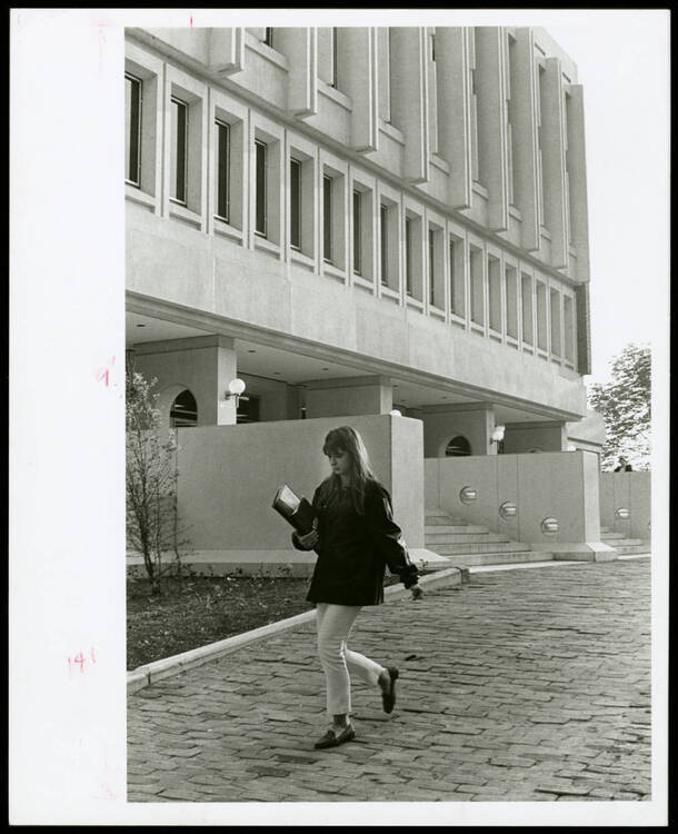 Student walking outside Alden Library fourth floor entrance, looking southwest, ca. 1969