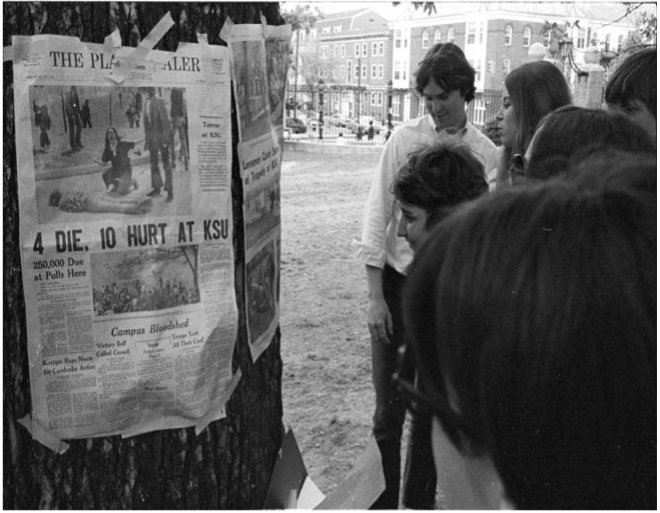 Students reading a newspaper about the Kent State shootings posted on the College Green. Photograph by Peter Goss.