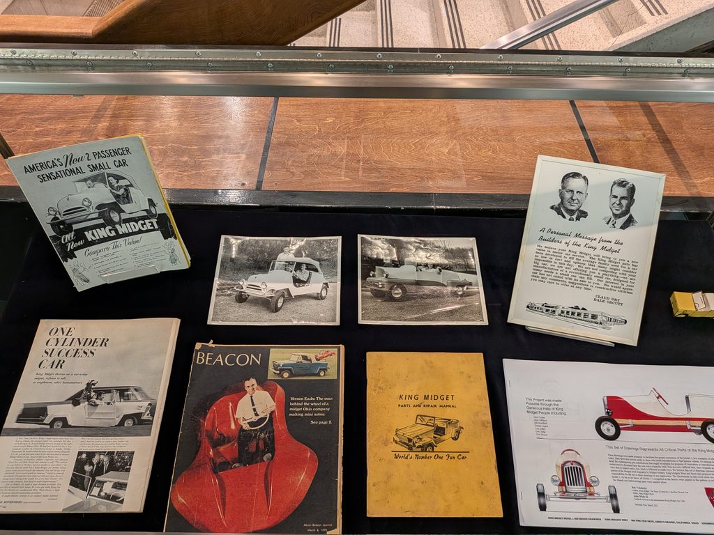 Articles, manuals, and photographs in an exhibit case.
