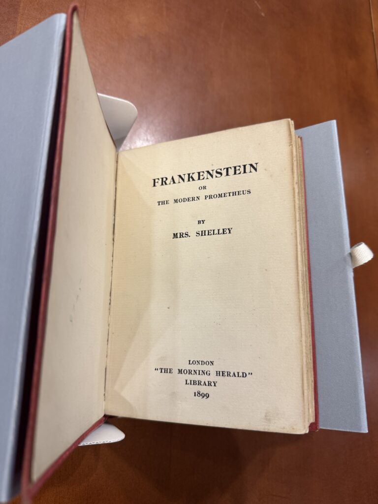 Title page stating “Frankenstein” in large, all caps serif font. “Or the Modern Prometheus by Mrs. Shelley” stated below in smaller text. At the bottom of the page “London “The Morning Herald” Library 1899” is printed. 