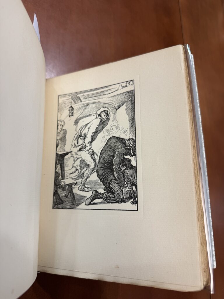Book is open on a brown table; an illustration of a woman in a large white fur coat and a man crouched beside her is featured in black ink. 