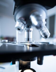 Detailed view of a laboratory microscope focusing on lens and optical components.